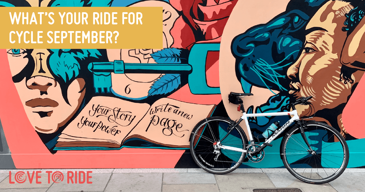 A bike propped up against a wall covered in a large colourful mural which contains images of faces, a key, and an open book containing the words ‘your story your power, write a new page’. The text on the asset says ‘what’s your ride for Cycle September?’. A bike propped up against a wall covered in a large colourful mural which contains images of faces, a key, and an open book containing the words ‘your story your power, write a new page’. The text on the asset says ‘what’s your ride for Cycle September?’.