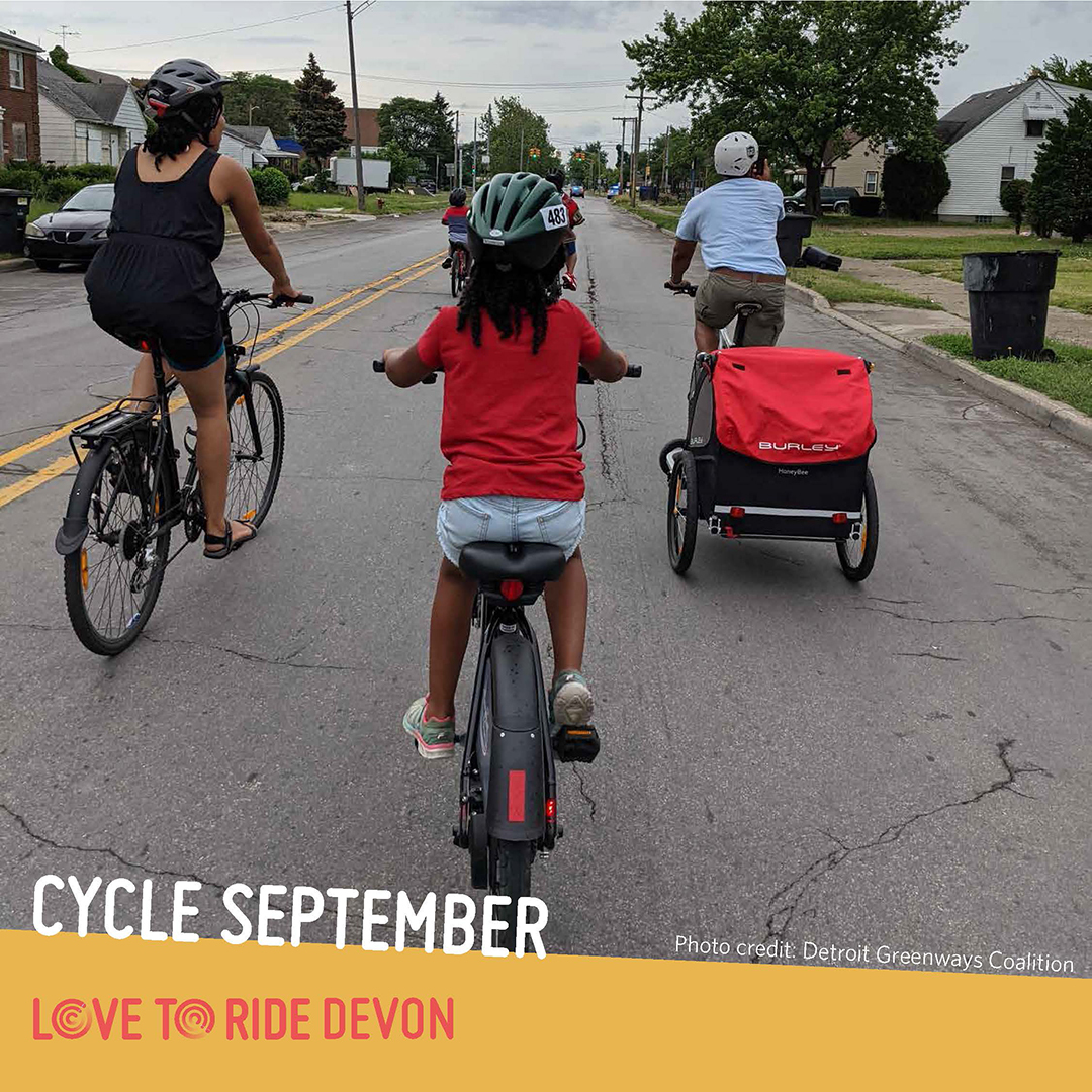 A family riding on a residential road, shown from behind. One person carries a trailer on their bike. The text says ‘Cycle September. Photo credit: Detroit Greenways Coalition’ and the Love to Ride logo is displayed. A family riding on a residential road, shown from behind. One person carries a trailer on their bike. The text says ‘Cycle September. Photo credit: Detroit Greenways Coalition’ and the Love to Ride logo is displayed.