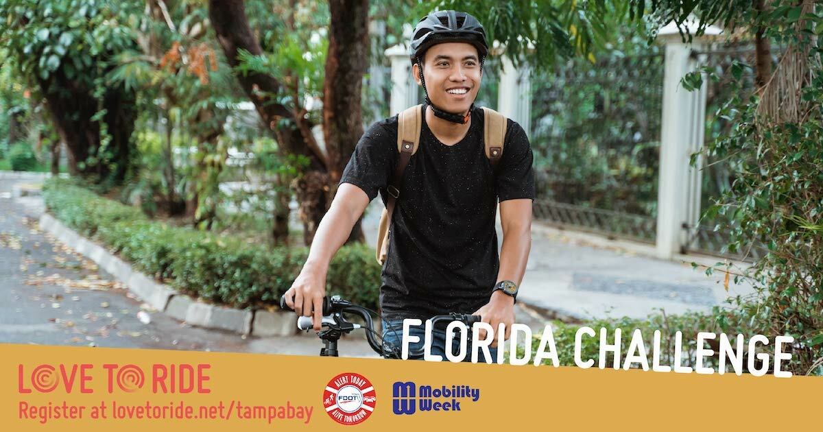A man smiling wearing a helmet, pushing his bike down the road. The text says Love to Ride Florida Challenge. A man smiling wearing a helmet, pushing his bike down the road. The text says Love to Ride Florida Challenge.