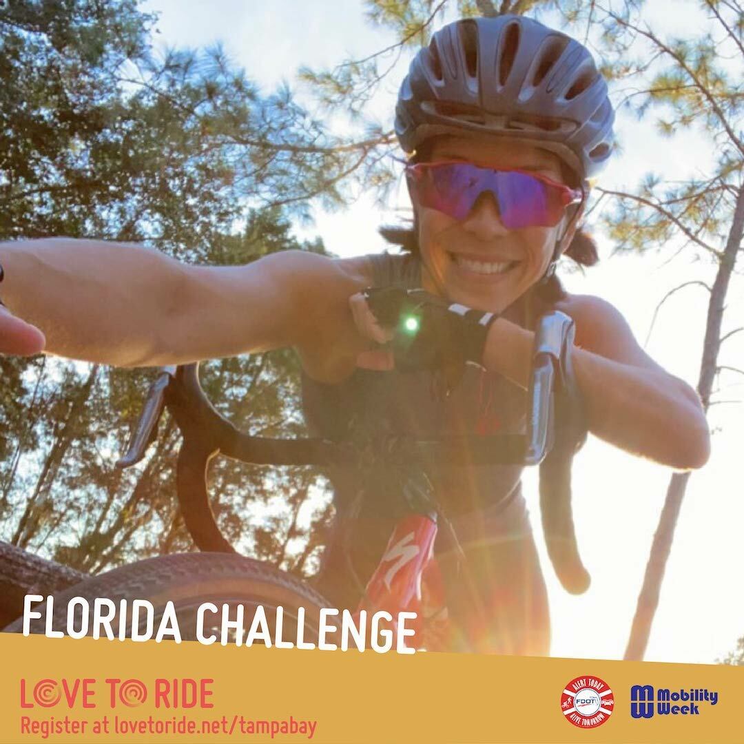 A selfie of a rider with a bike helmet, riding gloves and sunglasses on leaning over her handlebars to take the picture, with the sun and trees behind her. The text ‘Florida Challenge’ and logos for Love to Ride, Alert Today and Mobility Week. A selfie of a rider with a bike helmet, riding gloves and sunglasses on leaning over her handlebars to take the picture, with the sun and trees behind her. The text ‘Florida Challenge’ and logos for Love to Ride, Alert Today and Mobility Week.