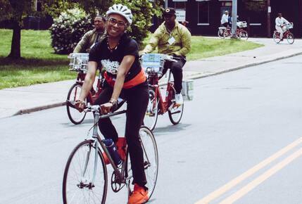 Person wearing a helmet riding a bike on the road.