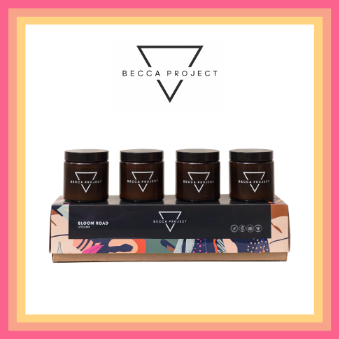 Four Becca Project candles sit on a box Four Becca Project candles sit on a box