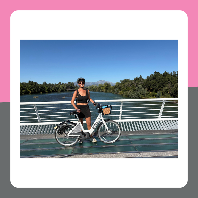 Woman stands in Shasta with herRedding Bikeshare bike. 